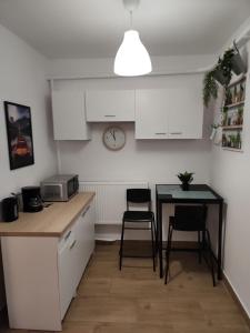 a kitchen with a table and chairs and a clock at Przytulne pokoje u Julii in Rzeszów