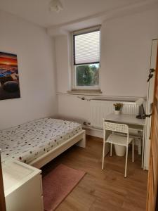 sypialnia z łóżkiem, biurkiem i oknem w obiekcie Przytulne pokoje u Julii w mieście Rzeszów