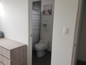 a white bathroom with a toilet and a sink at Playa el Silencio lindo apartamento! no mascotas deposito para reservar in Bombiso