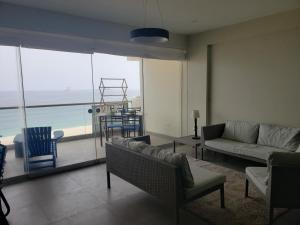 uma sala de estar com vista para o oceano em Playa el Silencio lindo apartamento! no mascotas deposito para reservar em Bombiso