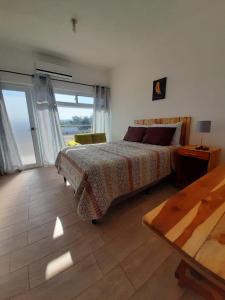 1 dormitorio con cama, mesa y ventana en Apartamentos Mundo Maya Habitaciones en Flores