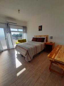 sypialnia z łóżkiem i drewnianą podłogą w obiekcie Apartamentos Mundo Maya Habitaciones w mieście Flores