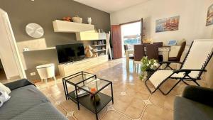 ein Wohnzimmer mit einem Sofa und einem Tisch in der Unterkunft Villa Lucia With Salt Pool in Fontane Bianche