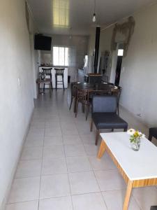 ein Wohnzimmer mit Tischen und Stühlen sowie eine Küche in der Unterkunft Casa Quinta Gualeguaychu in Gualeguaychú