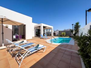 a patio with lounge chairs and a swimming pool at Casa Maddy - A charming location with every comfort in Playa Blanca