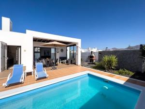 a villa with a swimming pool and a house at Casa Maddy - A charming location with every comfort in Playa Blanca