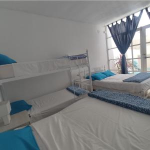 three bunk beds in a room with a window at Hospedaje El Candelabro de Paracas in Paracas