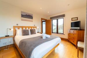 1 dormitorio con 1 cama grande y TV en Great Blasket, Dunquin, en Dunquin