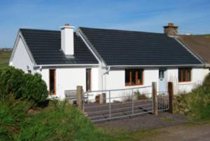 una casa blanca con techo negro en Great Blasket, Dunquin, en Dunquin