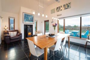 comedor con mesa de madera y sillas blancas en Great Blasket, Dunquin, en Dunquin