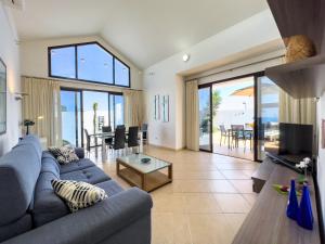 a living room with a blue couch and a table at Casa Maddy - A charming location with every comfort in Playa Blanca