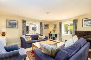 a living room with blue couches and a fireplace at Poachers Lodge in Yarmouth