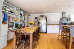 a kitchen with a table and chairs and a refrigerator at Poachers Lodge in Yarmouth