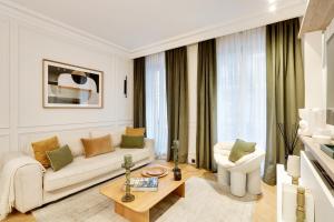 un soggiorno con divano bianco e tavolo di TheLander - Champs Elysées Serviced Apartments a Parigi