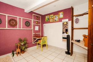 Habitación con paredes de color púrpura, mesa y escritorio. en Casa Amaranto en Panajachel