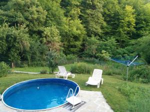 a swimming pool with two chairs and a table at Guest House Pepeliana in Sŭbotkovtsi