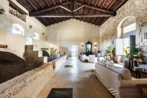 un ampio soggiorno con un grande muro in pietra di Masseria Costanza, Vendicari Retreat a Noto
