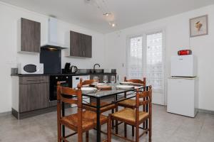 a kitchen with a table and chairs in a room at Gite du maine in Langon