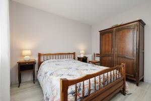 a bedroom with a wooden bed and a wooden dresser at Gite du maine in Langon