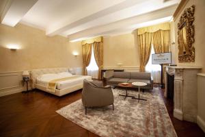 a bedroom with a bed and a couch and a table at Hotel Rua Frati 48 in San Francesco in Modena