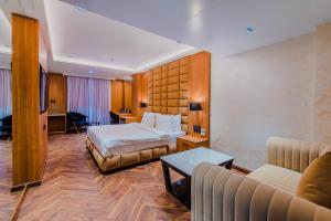 une chambre d'hôtel avec deux lits et un canapé dans l'établissement Grand Dhillon Hotel, à Bhilai