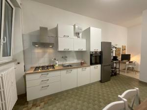 a kitchen with white cabinets and a black refrigerator at Casa Sofia Trastevere in Rome