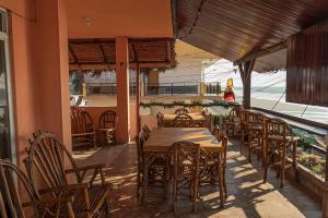 un restaurante con mesas y sillas de madera y un balcón en San Alejo Zero, en San Jacinto