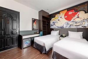 a hotel room with two beds and a painting on the wall at Hanoi Elpis Hotel & Spa in Hanoi