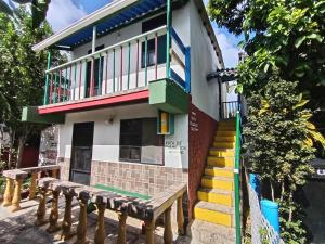 a house with a bench in front of it at Hospedaje Turistico Angula Place in San Andrés