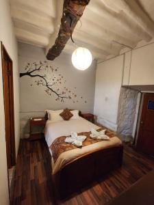 a bedroom with a bed with a tree mural on the wall at Pirwa Backpackers Colonial in Cusco