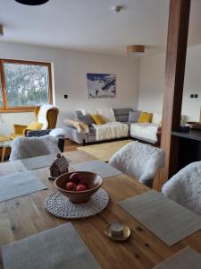 ein Wohnzimmer mit einem Tisch und einer Obstschale darauf in der Unterkunft Lucky Chalet Jasná in Demänovská Dolina
