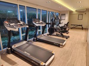a gym with three treadmills and two exercise bikes at Vicky the east ville Bangsean room 15 in Ban Hua Khao Sammuk