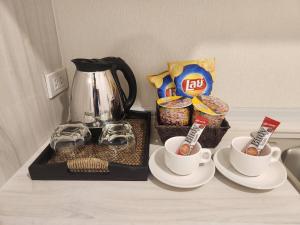 a table with two cups of coffee and snacks at Vicky the east ville Bangsean in Ban Hua Khao Sammuk