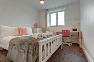 a bedroom with a bed and a desk and a window at Lillies House in Oxford