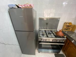 een keuken met een roestvrijstalen koelkast en een fornuis bij Cozy apartment near city center in Fès