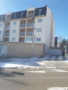 a building with a parking lot in front of it at Lux Apartman Jovana in Žabljak