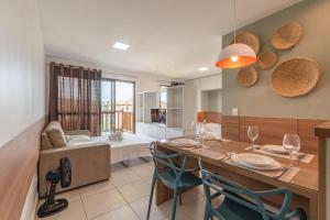 Il comprend une cuisine et un salon avec une table et des chaises. dans l'établissement VG Sun #409 - Apartamento em Cumbuco por Carpediem, à Caucaia