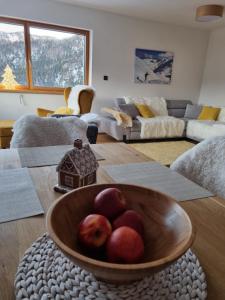 eine Schale mit Äpfeln auf einem Tisch im Wohnzimmer in der Unterkunft Lucky Chalet Jasná in Demänovská Dolina