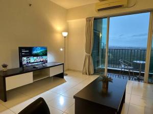 a living room with a television and a large window at Bayu Marina Resort 3 Bedroom in Johor Bahru