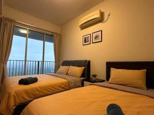 a bedroom with two beds and a window with a balcony at Bayu Marina Resort 3 Bedroom in Johor Bahru
