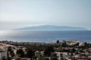 a view of a city and the ocean with a mountain at Ocean View 1 bedroom in Costa Adeje in Adeje
