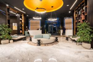 a lobby with couches and plants in a building at Dominium Hotel in Agadir