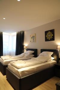 two beds in a bedroom with a window at Moaline Apartments, free parking in Sarajevo