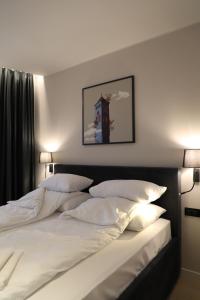 a bedroom with a large bed with white sheets and pillows at Moaline Apartments, free parking in Sarajevo