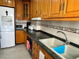 a kitchen with wooden cabinets and a white refrigerator at Casa Angela de Novelda in Novelda +7 photos