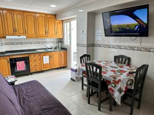 a kitchen with a table and a tv on the wall at Casa Angela de Novelda in Novelda