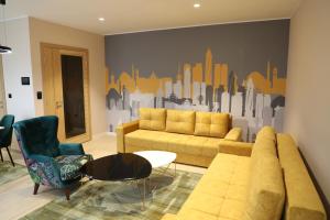 萨拉热窝Moaline Apartments, free parking的带沙发和城市壁画的客厅