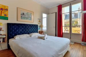 a bedroom with a large bed with a teddy bear on it at Sophisticated typically Parisian flat - Welkeys in Paris