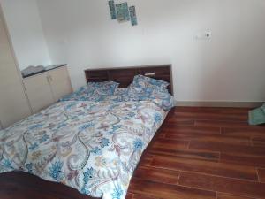 Bett in einem Schlafzimmer mit Holzboden in der Unterkunft Rivera Resort in Jammalamadugu