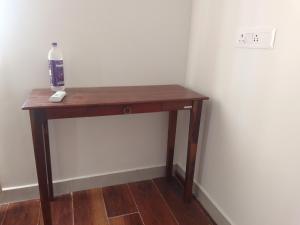 a small wooden table with a bottle of water on it at Rivera Resort- Night stay in Jammalamadugu